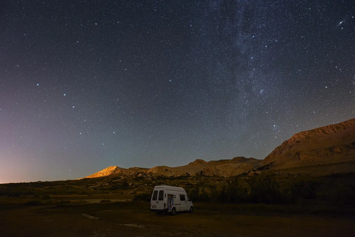 Camper van parked under a starry night sky