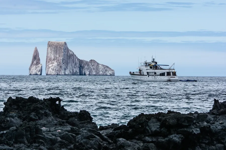 Rock formation and tour boat in the Galapagos, a typical Galapagos cruise scene